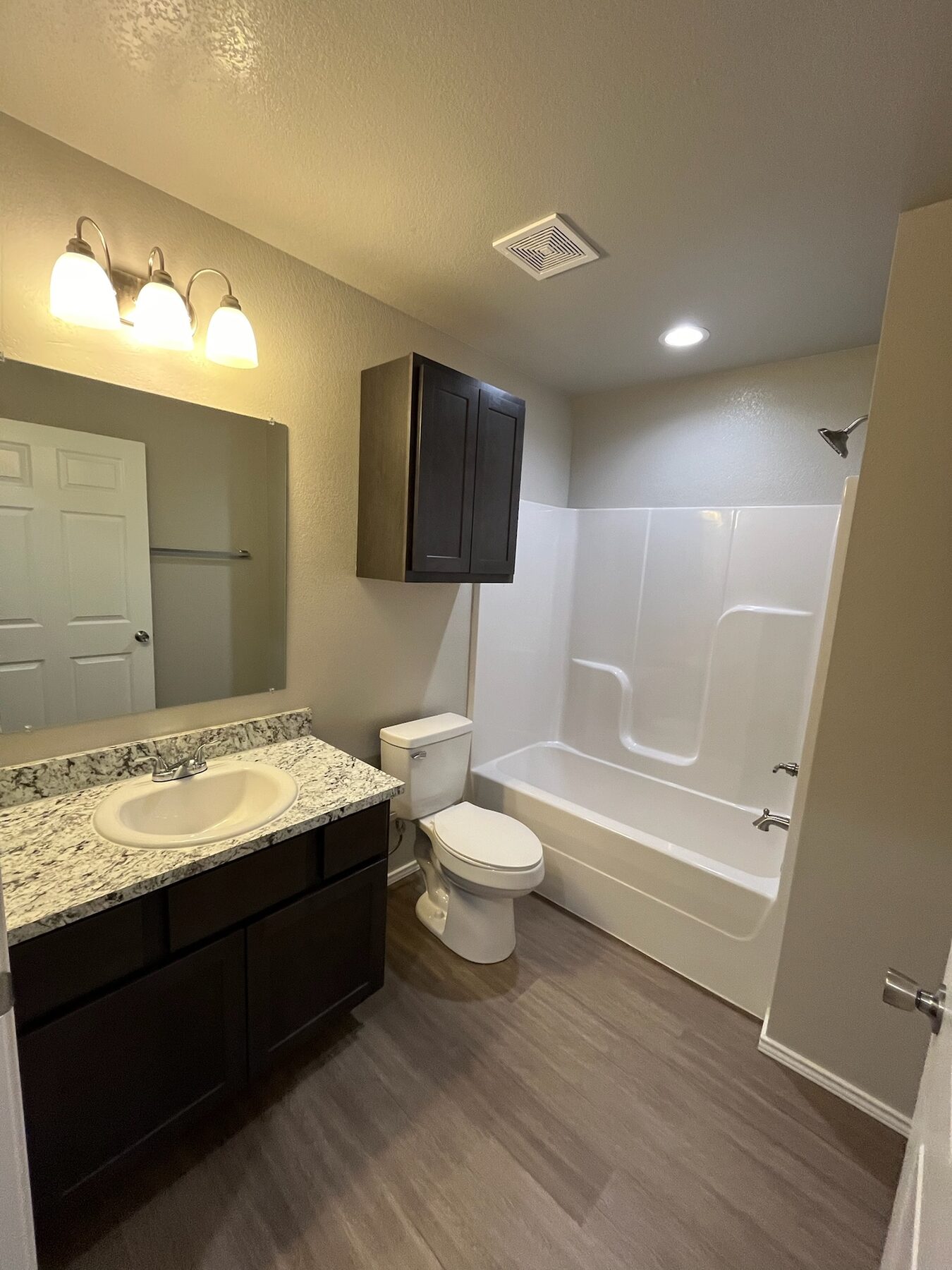 Finished bathroom remodel with granite vanity and bathtub