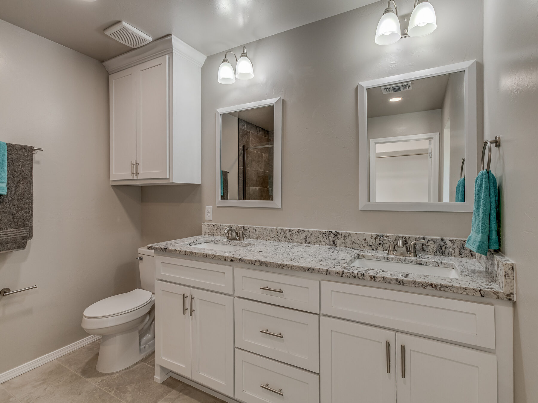 Double vanity bathroom with white cabinets and granite countertop in Norman, Oklahoma