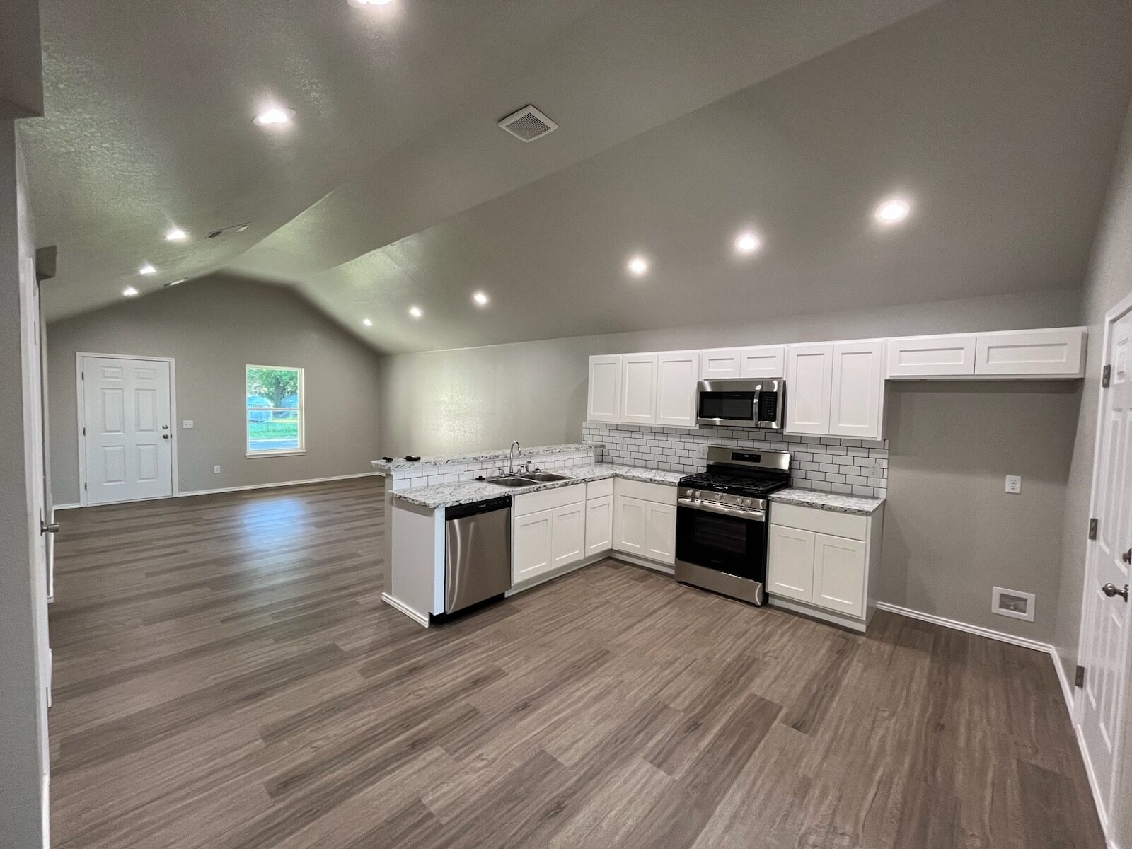 Renovated white kitchen connected to an open living area