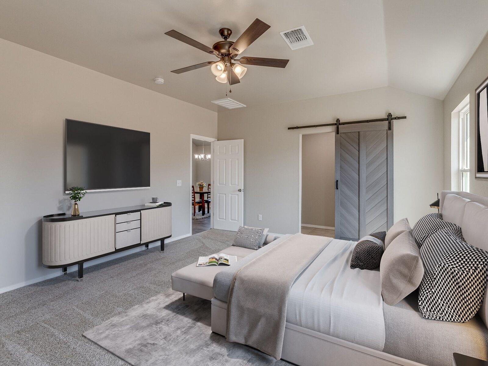 Finished bedroom with vaulted ceiling and sliding barn door
