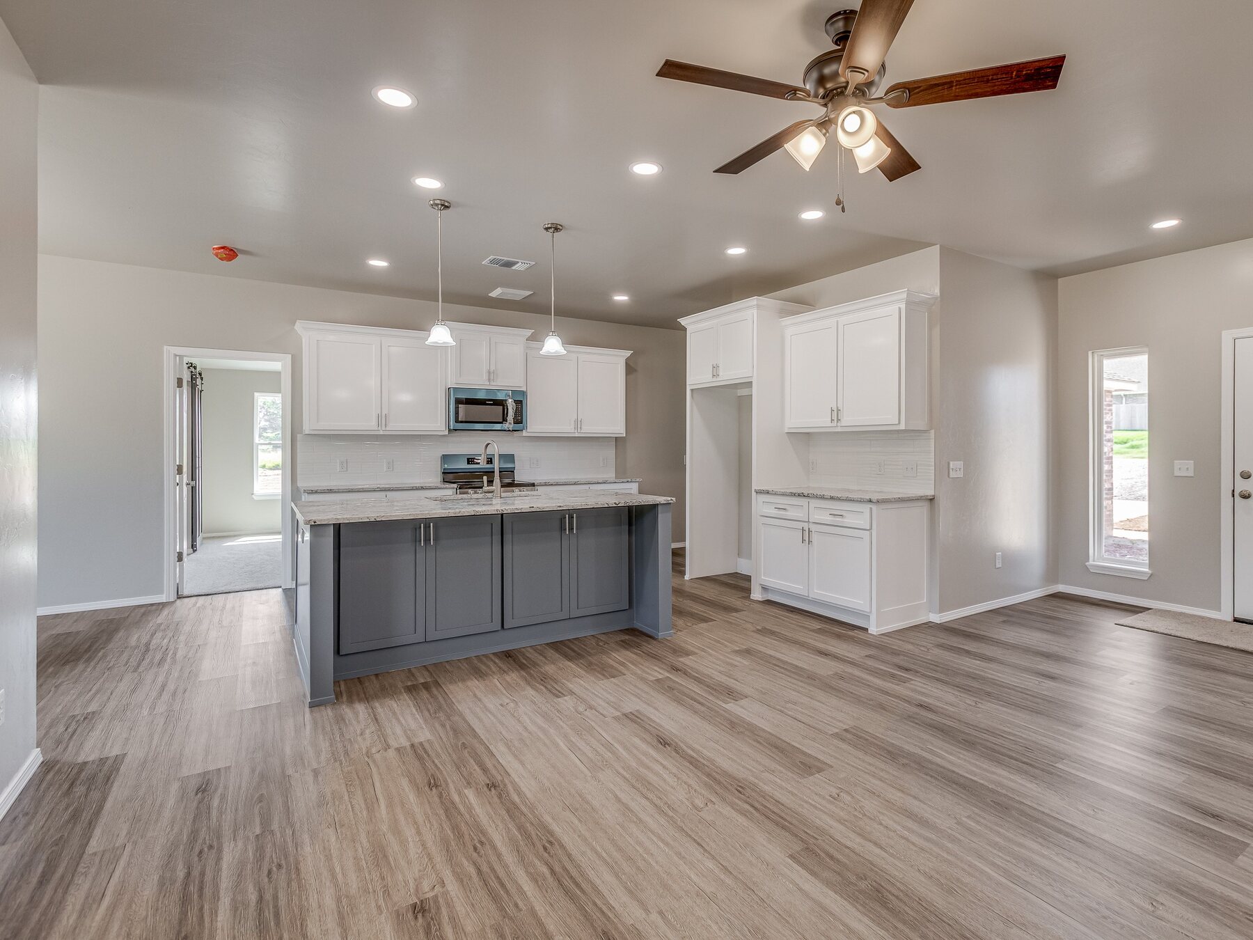 Finished kitchen with white cabinetry and a gray island